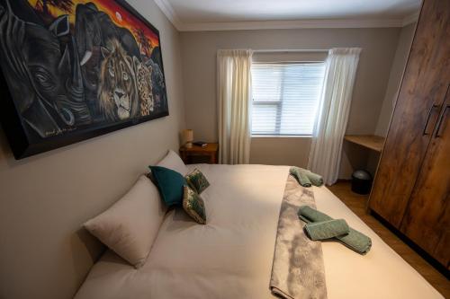 a bedroom with a white bed with pillows on it at Colchester Suites - Travel Addo Group in Cannonvale