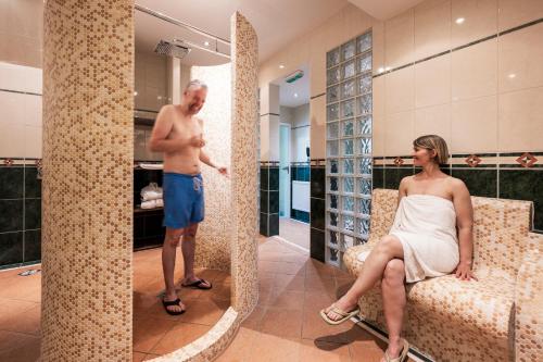 a man and a woman sitting in a tub in a bathroom at Parkhotel Klüschenberg in Plau am See