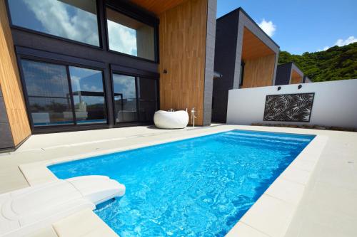 a swimming pool in the backyard of a house at Mare Blu Amami in Tatsugo