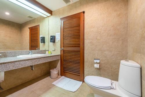 a bathroom with a toilet and a sink and a mirror at Sailom Resort Bangsaphan in Bang Saphan