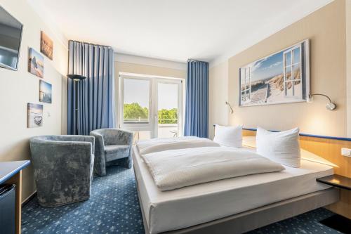 a hotel room with a bed and a chair at Parkhotel Klüschenberg in Plau am See