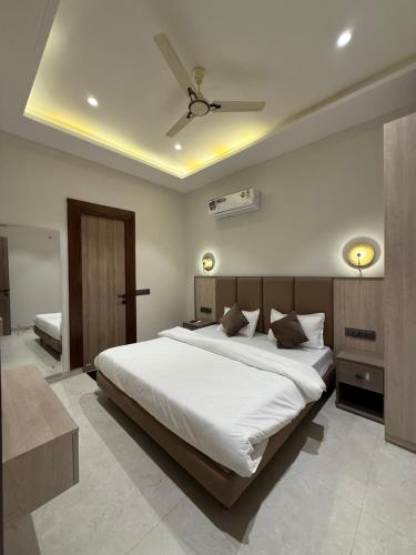 a bedroom with a large white bed and a ceiling at Hotel sky inn in Jalandhar