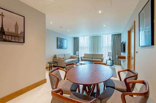 a living room with a table and chairs at Sanctum Belsize Road in London