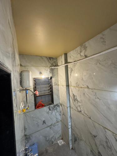 a bathroom being remodeled with a marble wall at Ramona homestay in Kolhapur