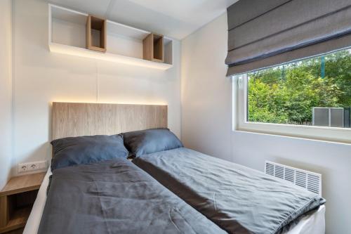 a small bedroom with a bed and a window at Holiday Home Tiny Haus Sunside in Riedenburg