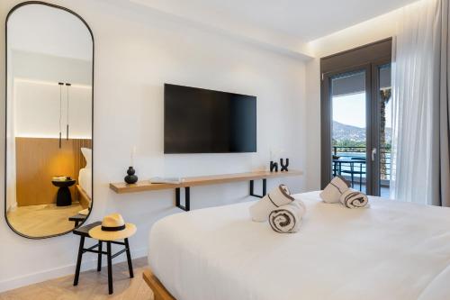 a bedroom with a large white bed with a large mirror at Urban Heights Ammoudi Seafront in Agios Nikolaos