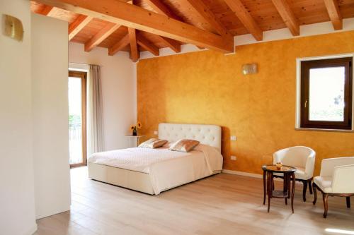 a bedroom with a bed and a table and chairs at Rama Relais in Caprino Veronese