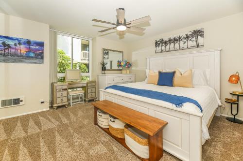 a bedroom with a bed with a ceiling fan and a desk at C4 - Coastal Cottage in Oceanside