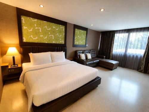 a bedroom with a large white bed and a couch at Aranta Suvarnabhumi in Lat Krabang