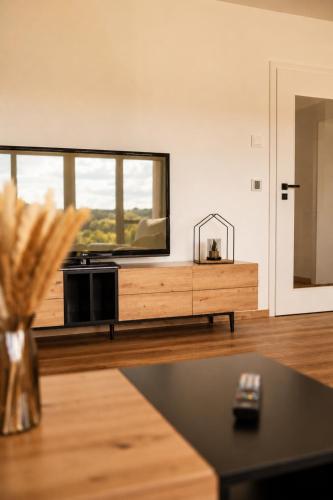 a living room with a tv and a table at Moderne Bauernhof Wohnung mitten in der Natur in Emtmannsberg