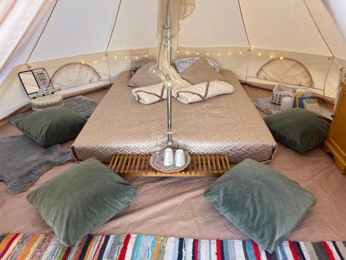 a tent with four pillows and a table in it at Ilmjärve Glamping Otepää in Ilmjärve