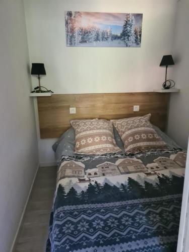 a bedroom with a bed with a wooden headboard at Agréable appartement-Résidence Le Panoramic in Les Angles