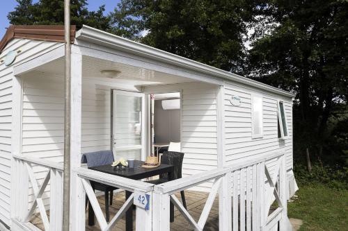 a small white shed with a table in it at Cottage 4 personnes in Mirepoix
