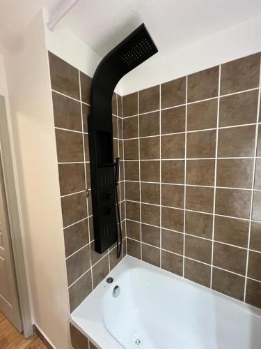 a bathroom with a bath tub and a tile wall at Bel appartement montagne in Albiez-Montrond