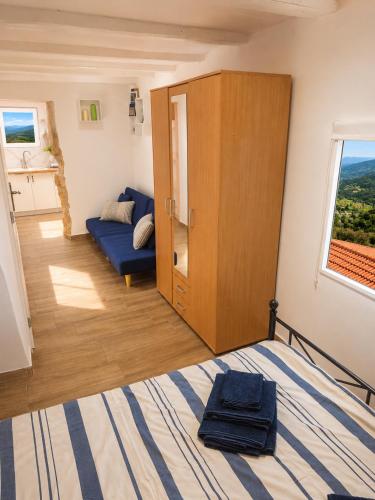 a bedroom with a bed and a cabinet and a couch at Sky Terrace retreat in Draga Bašćanska