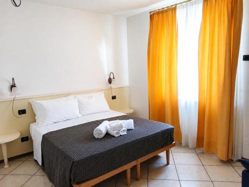 a bedroom with a bed with two towels on it at Le Camere DI Lucia Affittacamere in Colà di Lazise
