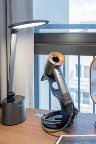 a desk with a hair dryer next to a computer monitor at Weave Suites - Sunyu Parkside in Seoul