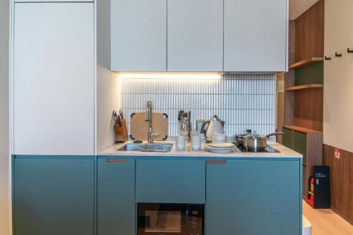 a kitchen with blue cabinets and a sink at Weave Suites - Sunyu Parkside in Seoul