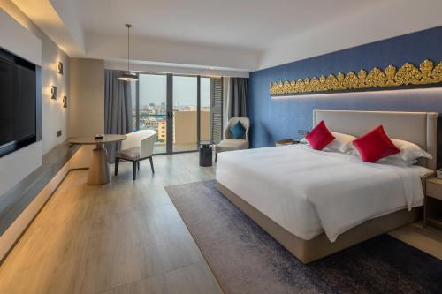 a hotel room with a large bed and a television at Tian Yi International Hotel 天艺国际酒店 in Phnom Penh