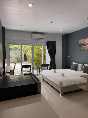 a bedroom with a bed and a table and chairs at Big Buddha Hillside Hotel in Phuket