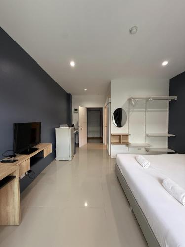 a bedroom with a large bed and a television at Big Buddha Hillside Hotel in Phuket