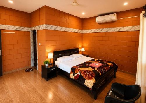 a bedroom with a bed with an orange wall at Sheen Villa Homestay in Varkala