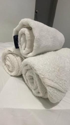 a pile of towels sitting on top of a bed at Enviropath Hotel now Bayan Nur Inn in Kampong Pengkalan