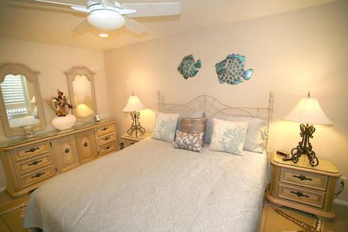 a bedroom with a bed and two dressers and a mirror at A209 - Sandy Paradise - On-the-Sand in Oceanside