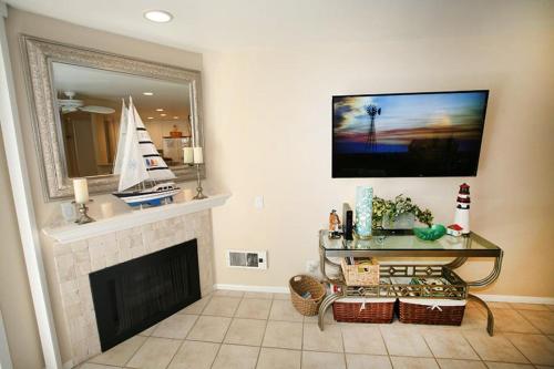 a living room with a fireplace and a tv at A209 - Sandy Paradise - On-the-Sand in Oceanside