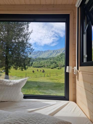 a bedroom with a large window looking out at a field at BONIS - Nidi nel Bosco in Montemaggiore