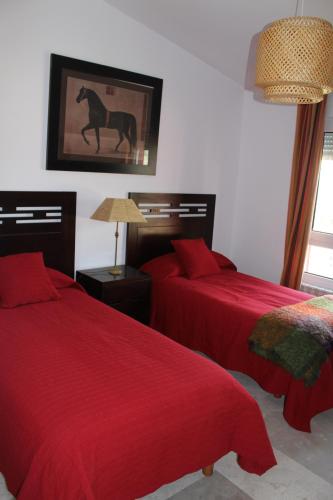 a bedroom with two beds and a picture of a horse on the wall at Finca el enebro in Valdemorillo