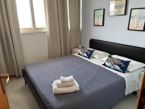 a bedroom with a bed with towels on it at Terrazza Fiumara in Letojanni