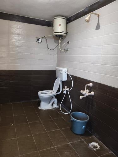 a bathroom with a toilet and a bucket at VISHAKA RESIDENCY yercaud in Siddhma