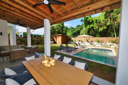 a patio with a table and chairs and a pool at Casa Rivera - 4 Bedrooms in West Bay