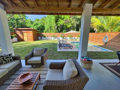 a patio with a couch and chairs and a pool at Casa Rivera - 4 Bedrooms in West Bay