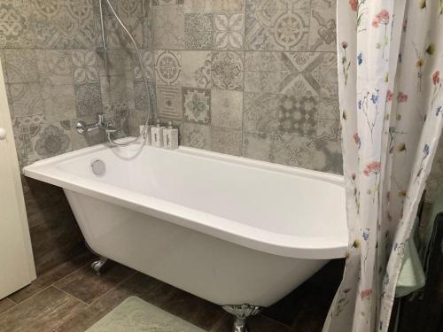 a white bath tub in a bathroom with a shower curtain at Ferienwohnung am Kinzigberg 5 in Schlüchtern