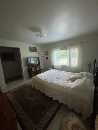 a bedroom with a white bed and a window at Studio Sillankorva in Viitasaari