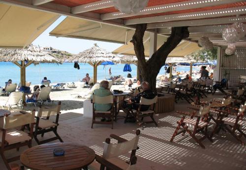 a group of people sitting at tables on the beach at Asteria Hotel in Naxos Chora