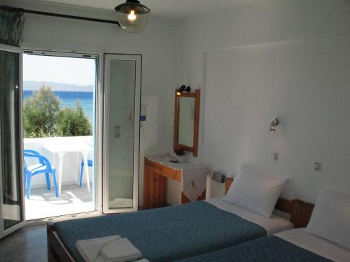a bedroom with a bed and a view of the ocean at Asteria Hotel in Naxos Chora