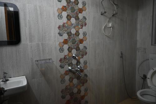 a wall in a bathroom with a toilet and a sink at Denzongpa Homestay in Takdāh