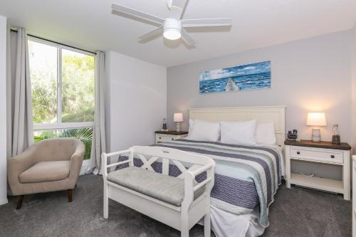 a bedroom with a bed and a chair and a window at D4 - Lighthouse on the Shore in Oceanside