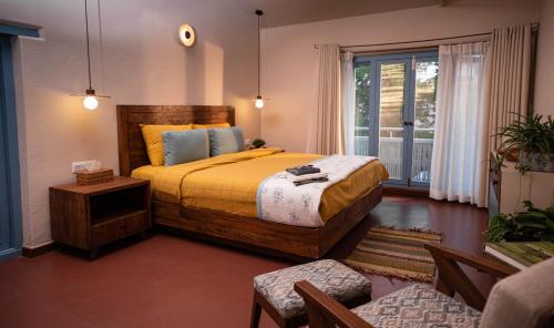 a bedroom with a large bed and a balcony at Garden Studio in Pātan