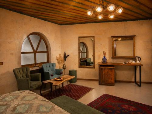 a bedroom with a bed and a table and a mirror at Premium Cappadocia in Göreme