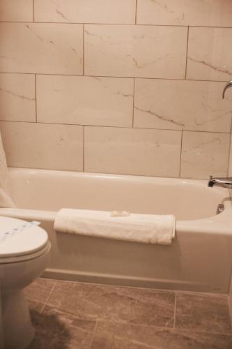a bathroom with a white tub and a toilet at St. Michaels Inn in Saint Michaels