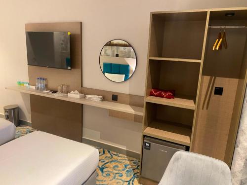a small room with a bed and a mirror at TAMARIND HOTEL in Dubai