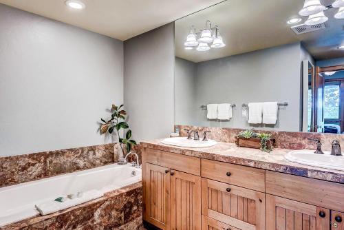 a bathroom with two sinks and a bath tub and a tubermott at 205 Bear Paw Lodge in Avon