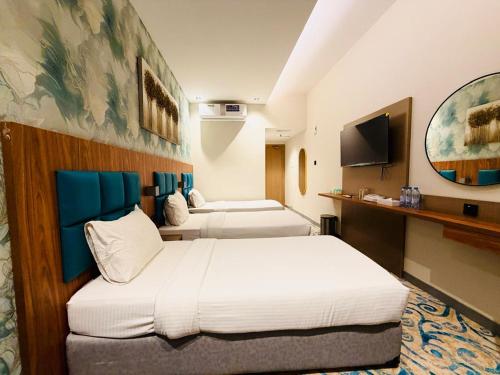 a hotel room with two beds and a flat screen tv at TAMARIND HOTEL in Dubai