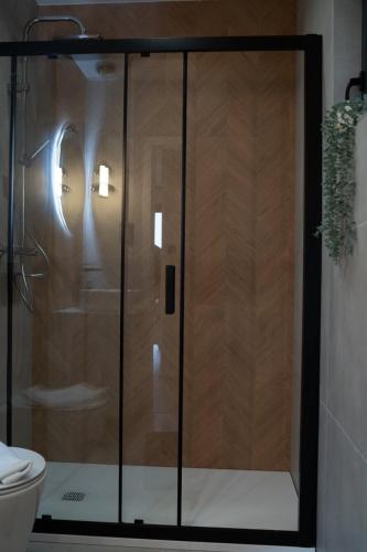 a shower with a glass door in a bathroom at Craftowe domki in Rusinowo