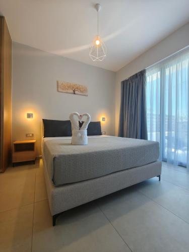 a bedroom with a large bed with a dress on it at Salt & Light House in Tigaki