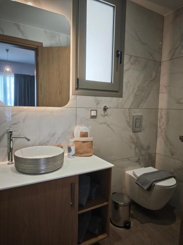 a bathroom with a sink and a toilet and a mirror at Salt & Light House in Tigaki